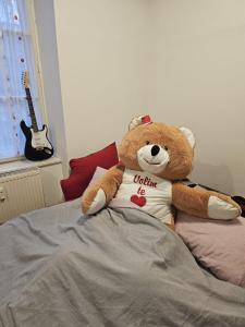 un orsacchiotto seduto sopra un letto di Trg republike a Sombor