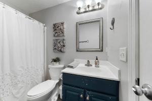 a bathroom with a toilet and a sink and a mirror at Sea Drift 102 by Carolina Beach Realty in Carolina Beach +40 photos