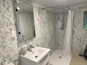 a white bathroom with a sink and a mirror at South London - Luxury Urban Cabin Retreat in Sutton +8 photos