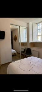 a bedroom with a bed and a mirror at Chez Louis in Saint-Flour