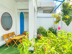 a patio with a wooden table and chairs and plants at Homestay Phúc Lộc in Îlot du Sud