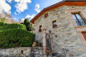 an old stone house with a stone wall at Ca' del Primo by Quokka 360 - A studio nestled in nature in Bidogno
