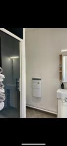 un bagno con una parete bianca con uno scaldabagno di Chez Louis a Saint-Flour Altre 37 foto