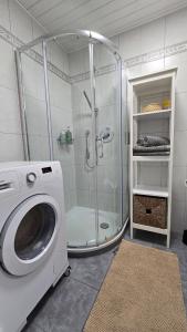 a bathroom with a shower and a washing machine at Hike, Bike & More in Parcines +33 photos