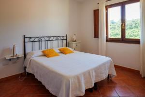 a bedroom with a bed with two orange pillows on it at La Colbula in Castelsardo