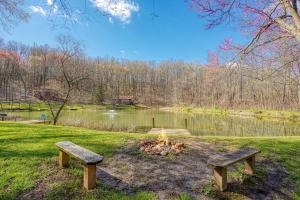 two benches sitting in front of a fire in a park at Wyandot Woods - Hillside in Laurelville