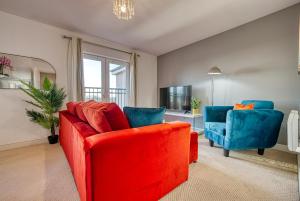 a living room with a red couch and two blue chairs at Peaceful 2-Bed in Sutton Coldfield, Near Parks in Sutton Coldfield