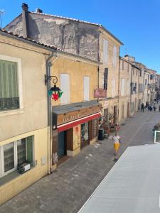 a person walking down a street next to buildings at Logement clim et patio centre remparts in Aigues-Mortes +14 photos