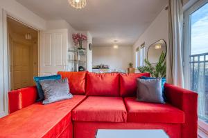 a red couch in a living room with a window at Peaceful 2-Bed in Sutton Coldfield, Near Parks in Sutton Coldfield +6 photos