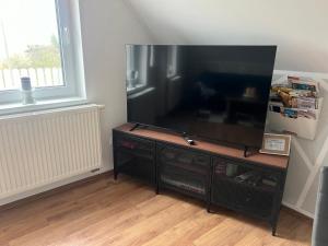 einen großen Flachbild-TV auf einem Stand in einem Zimmer in der Unterkunft Ferienwohnungen AugenBlick 2 Naumburg in Naumburg