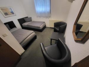 a room with two beds and a chair and a desk at Boardinghouse-Aparthotel mit Parkplatz Küche WIFI in Bielefeld +4 photos