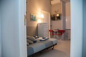 a bedroom with a bed and a table with a red chair at la dimora di Venere in Gaeta