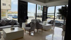 a living room with couches and tables and windows at فندق رويال دايموند إحدى فنادق مجموعة لوريف By Le Reve Company in Taif