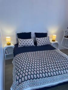 a bedroom with a large bed with two lights on it at La Petite Jeannette Studio in Rouen