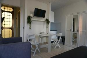 a living room with a white table and chairs at Central View Loft in Lignano Sabbiadoro