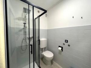 a bathroom with a toilet and a glass shower at Central View Loft in Lignano Sabbiadoro +4 photos