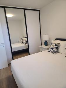 a bedroom with a white bed and a mirror at Apartment Anna in Čapljina