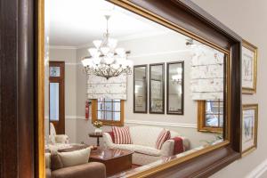 a mirror reflecting a living room with a chandelier at Mount Currie Inn in Kokstad +28 photos