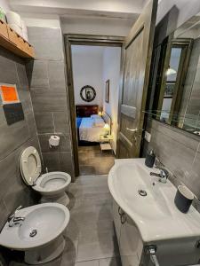 a bathroom with a toilet and a sink and a bed at Casa Vacanze da Anna e Turi in Solità