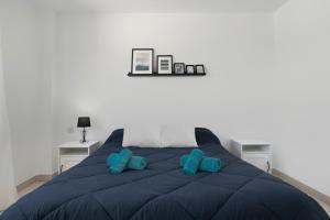 a bed with two blue pillows on top of it at Bonita Casa Adosada in Zahara de los Atunes +20 photos