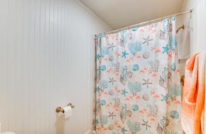 a bathroom with a shower curtain with flowers on it at Boat Slip and Fire Pit Peaceful House in Homosassa +23 photos