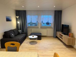 a living room with a couch and a tv at Sonnenhang Bayern in Grabenstätt