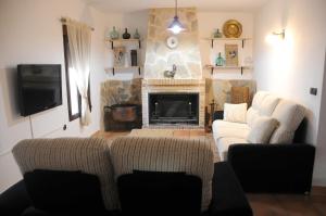 a living room with two couches and a fireplace at Casa Rural El Gallo in Casas de Haro