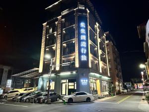 a building with cars parked in front of it at night at Hotel Jiji Plus in Ch'ai-ch'iao-t'ou