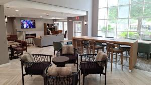 a restaurant with chairs and a table and a bar at Staybridge Suites Austin Airport by IHG in Austin