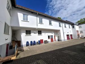 a white building with blue chairs in the courtyard at Landhotel Solmser Hof GbR in Echzell