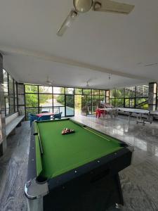 a pool table in a large room with windows at Eco farmville in Hyderabad