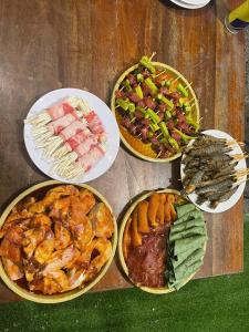 a table topped with different types of food on plates at Rice straw Green lodge- resort in Quan Tom