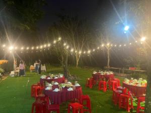 a group of tables with red chairs and lights at Rice straw Green lodge- resort in Quan Tom +108 photos
