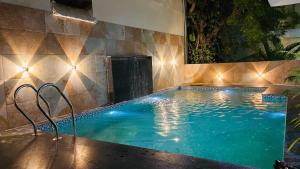 a large swimming pool with lights in a house at Braj Villa in Udaipur