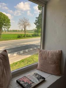 ein Buch auf einer Fensterbank mit Blick auf eine Straße in der Unterkunft La seiche in Kluisbergen