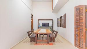 a dining room with a table and a mirror at Casa Aconchegante em Bertioga a 700m da Praia in Bertioga
