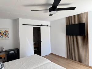 a bedroom with a ceiling fan and a television on the wall at ROVIOR Rooms & Café in Calafell +47 photos