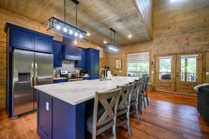 a kitchen with blue cabinets and a large kitchen island with chairs at Serenity Pines-3bd/2bth, Sleeps 8, Hot tub+Arcades in Stephens Gap