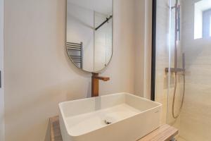 a bathroom with a white sink and a mirror at Studio lumineux avec terrasse, à deux pas de Lyon in Écully