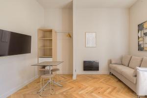 a living room with a couch and a table at Studio lumineux avec terrasse, à deux pas de Lyon in Écully
