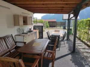 a patio with a table and chairs and a kitchen at Casa Dobro Dubova in Dubova