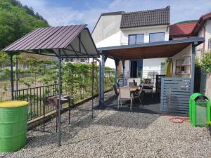 a patio with a table and chairs under an umbrella at Casa Dobro Dubova in Dubova