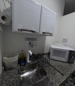 a kitchen counter with a sink and a microwave at HAUSHostel in Vinhedo