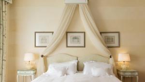 um quarto com uma cama de dossel e almofadas brancas em Hotel Rivalago em Sulzano