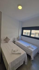 due letti in una stanza con finestra di Edificio Calpe Beach Arenal a Calpe