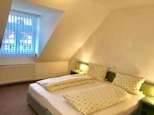 a bedroom with a bed with two pillows and a window at Landhotel Solmser Hof GbR in Echzell +52 photos