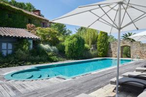 an umbrella and chairs next to a swimming pool at Villa Askizu by FeelFree Rentals in Getaria