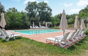 a pool with lounge chairs and umbrellas next to it at Stunning Home In Spoleto in Spoleto +33 photos