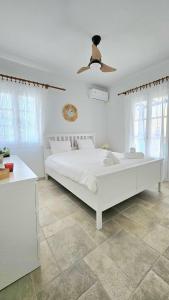 a white bedroom with a white bed and a ceiling at Tinos Seaside Gem - Cycladic 2BR 500m from Center in Tinos Town