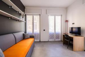 a room with a couch and a desk and a television at Casa Blue Moon in Baveno